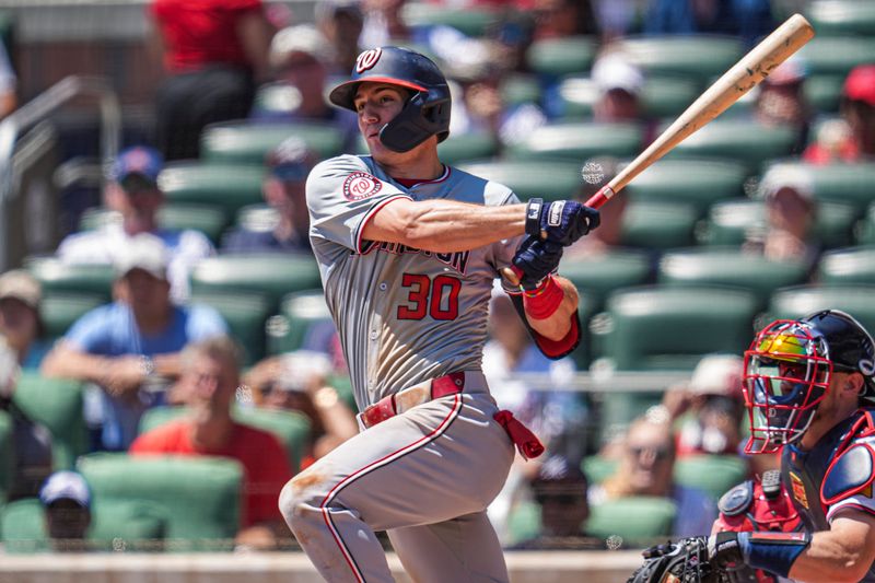 Aug 25, 2024; Cumberland, Georgia, USA; Washington Nationals center fielder Jacob Young (30) hits a double to drive in a run against the Atlanta Braves during the seventh inning at Truist Park. Mandatory Credit: Dale Zanine-USA TODAY Sports