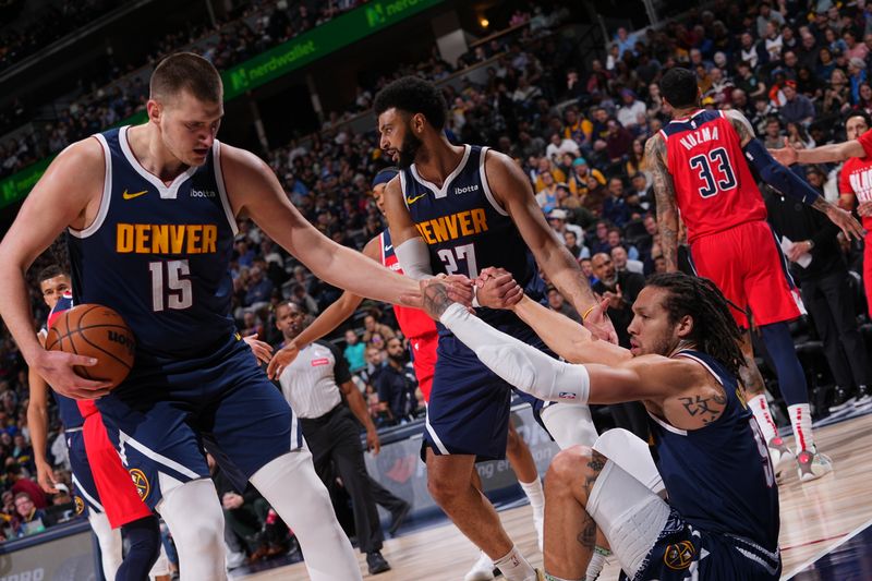 DENVER, CO - FEBRUARY 22: Aaron Gordon #50 of the Denver Nuggets is helped up by Nikola Jokic #15 and Jamal Murray #27 during the game against the Washington Wizards on February 22, 2024 at the Ball Arena in Denver, Colorado. NOTE TO USER: User expressly acknowledges and agrees that, by downloading and/or using this Photograph, user is consenting to the terms and conditions of the Getty Images License Agreement. Mandatory Copyright Notice: Copyright 2024 NBAE (Photo by Bart Young/NBAE via Getty Images)