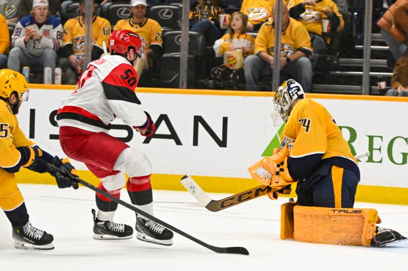 Dec 17, 2025; Nashville, Tennessee, USA;  Nashville Predators goaltender Juuse Saros (74) blocks the shot of Carolina Hurricanes left wing Eric Robinson (50) during the second period at Bridgestone Arena. Mandatory Credit: Steve Roberts-Imagn Images