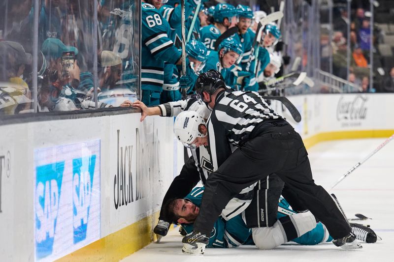 Apr 4, 2024; San Jose, California, USA; Linesman Brandon Gawryletz (64) separates Los Angeles Kings defenseman Andreas Englund (5) and San Jose Sharks center Luke Kunin (11) after a fight during the second period at SAP Center at San Jose. Mandatory Credit: Robert Edwards-USA TODAY Sports