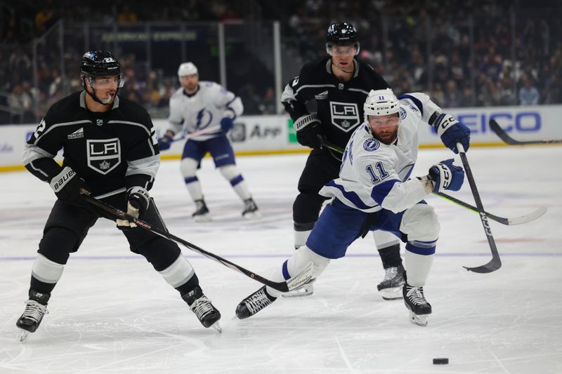 Mar 23, 2024; Los Angeles, California, USA; Tampa Bay Lighting center Luke Glendening (11) and Los Angeles Kings left wing Kevin Fiala (22) chase the puck during the third period of an NHL hockey game at Crypto.com Arena. Mandatory Credit: Yannick Peterhans-USA TODAY Sports