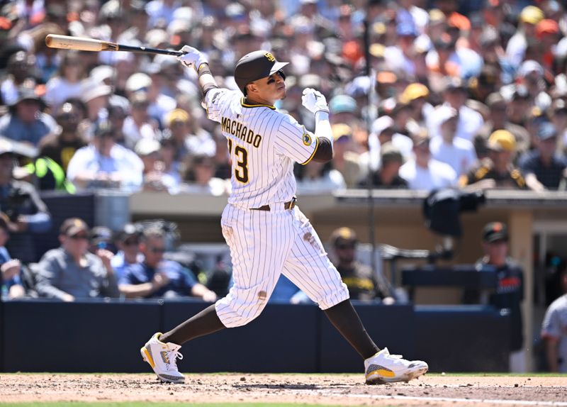 Apr 30, 2025; San Diego, California, USA; San Diego Padres third baseman Manny Machado (13) hits an RBI single during the fifth inning at Petco Park. Mandatory Credit: Denis Poroy-Imagn Images