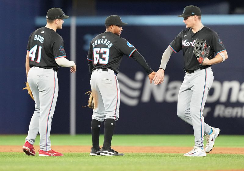 Sep 27, 2024; Toronto, Ontario, CAN; Miami Marlins shortstop Xavier Edwards (63) celebrates the win with left fielder Griffin Conine (56) after the game against the Toronto Blue Jays at Rogers Centre. Mandatory Credit: Nick Turchiaro-Imagn Images