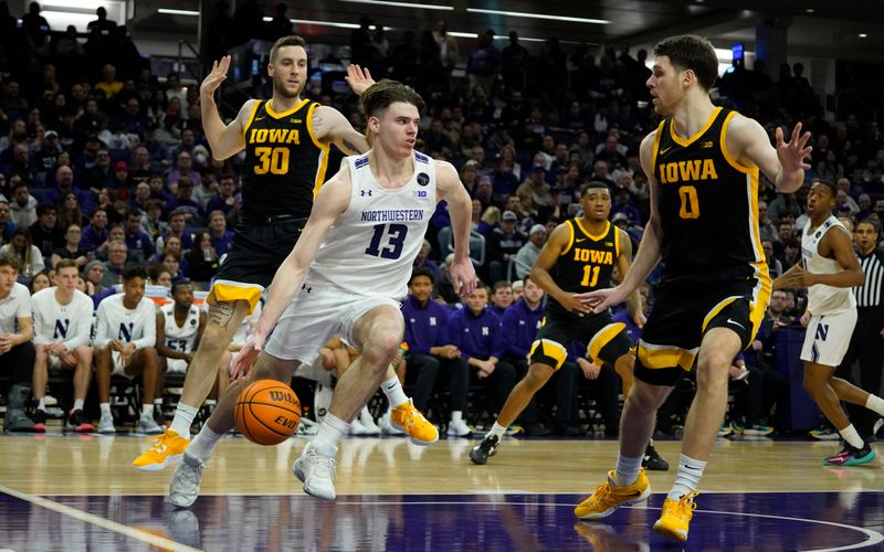 Feb 19, 2023; Evanston, Illinois, USA; Northwestern Wildcats guard Brooks Barnhizer (13) drives on Iowa Hawkeyes forward Filip Rebraca (0) during the second half at Welsh-Ryan Arena. Mandatory Credit: David Banks-USA TODAY Sports