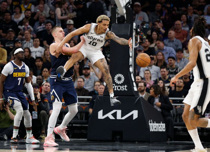 AUSTIN, TX - MARCH 15: Jeremy Sochan #10 of the San Antonio Spurs reaches for a loose ball in front of Nikola Jokic #15 of the Denver Nuggets in the second half at Moody Center on March 15, 2024 in Austin, Texas. NOTE TO USER: User expressly acknowledges and agrees that, by downloading and or using this photograph, User is consenting to terms and conditions of the Getty Images License Agreement. (Photo by Ronald Cortes/Getty Images)