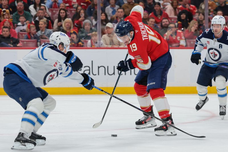 Jan 31, 2026; Sunrise, Florida, USA; Florida Panthers left wing Matthew Tkachuk (19) moves the puck against Winnipeg Jets defenseman Elias Salomonsson (57) during the second period at Amerant Bank Arena. Mandatory Credit: Sam Navarro-Imagn Images