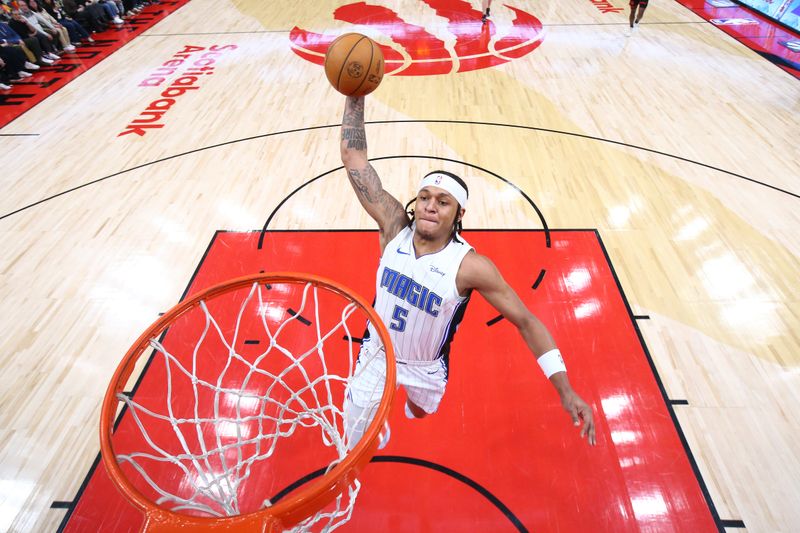 TORONTO, CANADA - MARCH 15:  Paolo Banchero #5 of the Orlando Magic drives to the basket during the game against the Toronto Raptors on March 15, 2024 at the Scotiabank Arena in Toronto, Ontario, Canada.  NOTE TO USER: User expressly acknowledges and agrees that, by downloading and or using this Photograph, user is consenting to the terms and conditions of the Getty Images License Agreement.  Mandatory Copyright Notice: Copyright 2024 NBAE (Photo by Vaughn Ridley/NBAE via Getty Images)