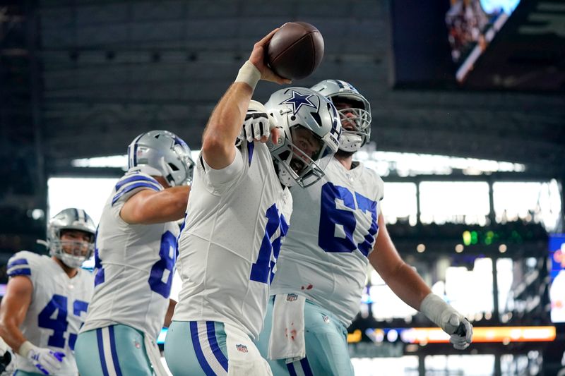 Dallas Cowboys quarterback Will Grier (15) and center Brock Hoffman (67) celebrate after Grier scored a touchdown running the ball in the first half of a preseason NFL football game against the Las Vegas Raiders in Arlington, Texas, Saturday, Aug. 26, 2023. (AP Photo/Sam Hodde)