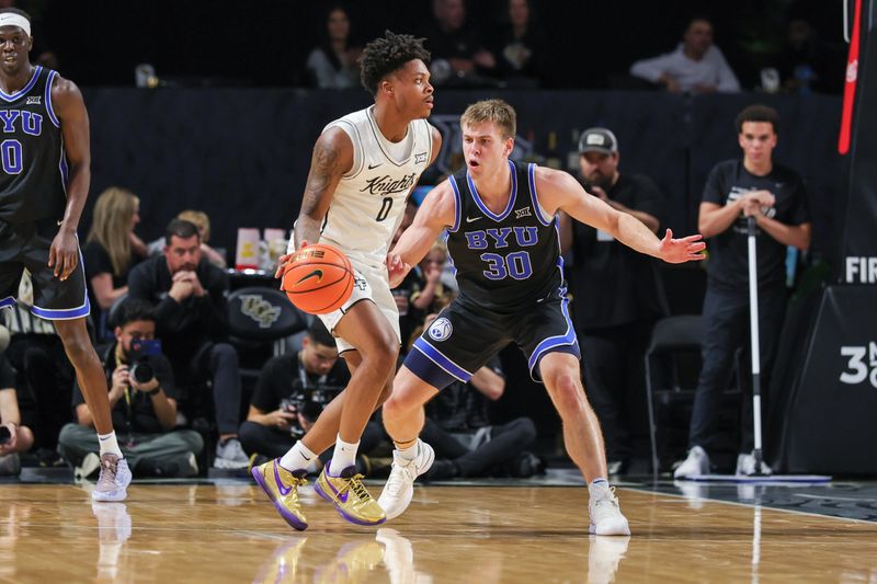 Feb 1, 2025; Orlando, Florida, USA; Brigham Young Cougars guard Dallin Hall (30) defends UCF Knights guard Jordan Ivy-Curry (0) during the second half at Addition Financial Arena. Mandatory Credit: Mike Watters-Imagn Images