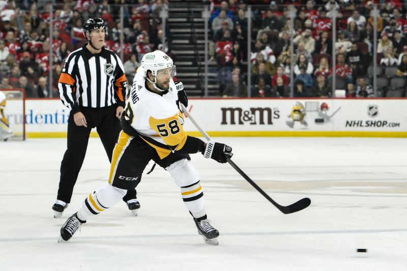 Apr 2, 2024; Newark, New Jersey, USA; Pittsburgh Penguins defenseman Kris Letang (58) shoots the puck during the first period against the New Jersey Devils at Prudential Center. Mandatory Credit: John Jones-USA TODAY Sports