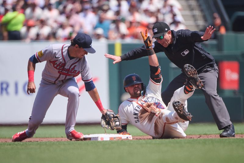 Aug 26, 2023; San Francisco, California, USA; Second base umpire Chris Guccione makes the safe sign after San Francisco Giants infielder J.D. Davis (7) slid into second base against Atlanta Braves infielder Orlando Arcia (11) during the second inning at Oracle Park. Mandatory Credit: Robert Edwards-USA TODAY Sports