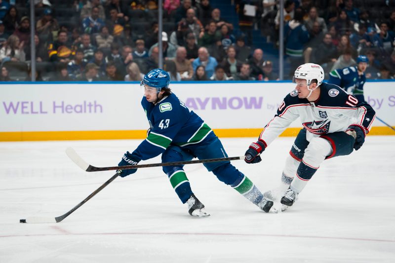 Nov 8, 2025; Vancouver, British Columbia, CAN; Columbus Blue Jackets forward Dmitri Voronkov (10) stick checks Vancouver Canucks defenseman Quinn Hughes (43) in the third period at Rogers Arena. Mandatory Credit: Bob Frid-Imagn Images