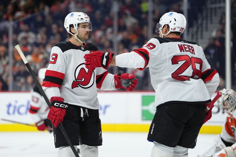 Nov 22, 2025; Philadelphia, Pennsylvania, USA; New Jersey Devils center Nico Hischier (13) reacts with right wing Timo Meier (28) after scoring a goal against the Philadelphia Flyers in the second period at Xfinity Mobile Arena. Mandatory Credit: Kyle Ross-Imagn Images