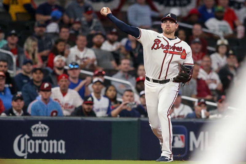 Oct 12, 2022; Atlanta, Georgia, USA; Atlanta Braves third baseman Austin Riley (27) fields the ball and throws out Philadelphia Phillies first baseman Rhys Hoskins (17) at first base in the first inning during game two of the NLDS for the 2022 MLB Playoffs at Truist Park. Mandatory Credit: Brett Davis-USA TODAY Sports