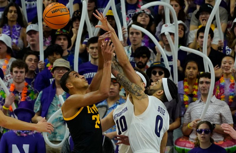 Feb 19, 2023; Evanston, Illinois, USA; Northwestern Wildcats guard Boo Buie (0) defends Iowa Hawkeyes forward Kris Murray (24) during the second half at Welsh-Ryan Arena. Mandatory Credit: David Banks-USA TODAY Sports