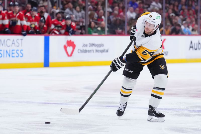 Jan 3, 2025; Sunrise, Florida, USA; Pittsburgh Penguins defenseman Matt Grzelcyk (24) shoots the puck against the Florida Panthers during the second period at Amerant Bank Arena. Mandatory Credit: Rich Storry-Imagn Images