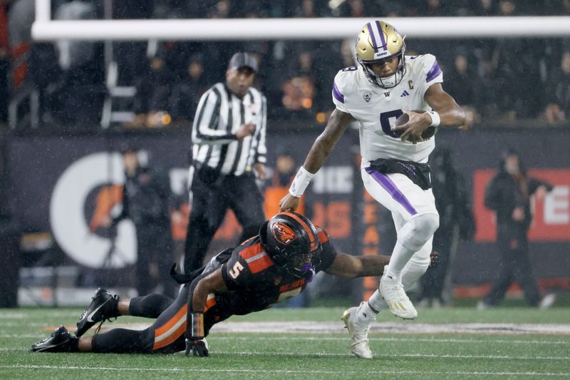 Nov 18, 2023; Corvallis, Oregon, USA; Washington Huskies  quarterback Michael Penix Jr. (9) escapes a tackle by Oregon State Beavers linebacker Easton Mascarenas-Arnold (5) during the first half at Reser Stadium. Mandatory Credit: Soobum Im-USA TODAY Sports