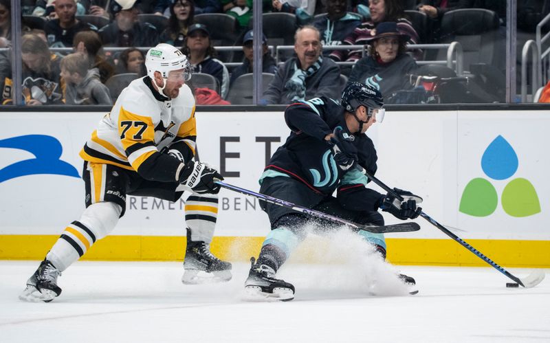 Feb 29, 2024; Seattle, Washington, USA; Seattle Kraken defenseman Brian Dumoulin (8) skates against Pittsburgh Penguins forward Jeff Carter (77) during the first period at Climate Pledge Arena. Mandatory Credit: Stephen Brashear-USA TODAY Sports