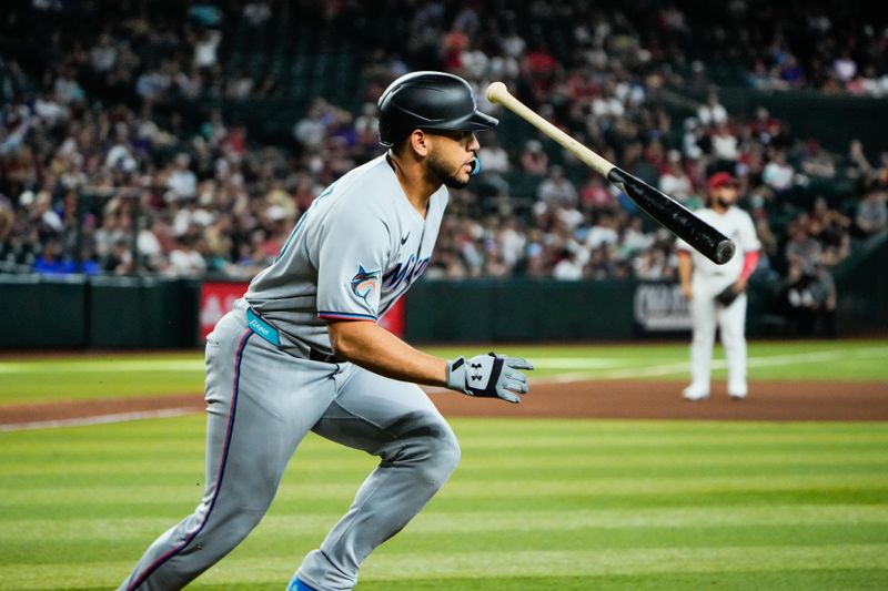 Jun 28, 2025; Phoenix, Arizona, USA; Miami Marlins catcher Agustín Ramírez (50) flips his bat after hitting an RBI single in the tenth inning against the Arizona Diamondbacks at Chase Field. Mandatory Credit: Arianna Grainey-Imagn Images