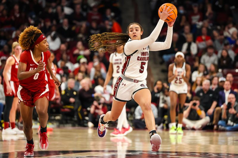 Feb 22, 2024; Columbia, South Carolina, USA; South Carolina Gamecocks guard Tessa Johnson (5) brings the ball up past Alabama Crimson Tide guard Loyal McQueen (0) in the first half at Colonial Life Arena. Mandatory Credit: Jeff Blake-USA TODAY Sports