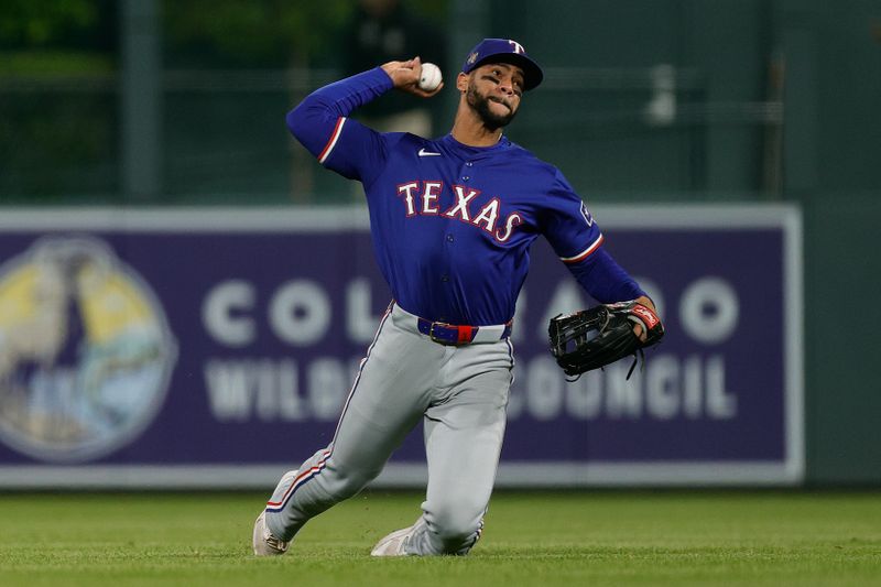 May 10, 2024; Denver, Colorado, USA; Texas Rangers center fielder Leody Taveras (3) throws from his knees after dropping the ball in the seventh inning against the Colorado Rockies at Coors Field. Mandatory Credit: Isaiah J. Downing-USA TODAY Sports
