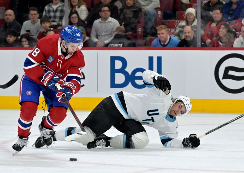 Nov 26, 2024; Montreal, Quebec, CAN; Montreal Canadiens defenseman Lane Hutson (48) takes the puck away from Utah Hockey Club forward Dylan Guenther (11) during the second period at the Bell Centre. Mandatory Credit: Eric Bolte-Imagn Images