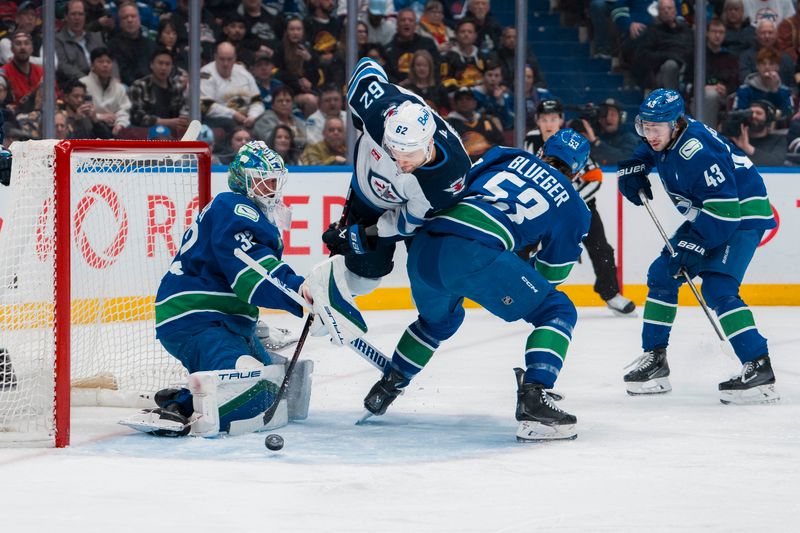 Mar 18, 2025; Vancouver, British Columbia, CAN; Vancouver Canucks defenseman Quinn Hughes (43) watches as goalie Kevin Lankinen (32) makes a save while forward Teddy Blueger (53) battles with Winnipeg Jets forward Nino Niederreiter (62) in the first period at Rogers Arena. Mandatory Credit: Bob Frid-Imagn Images