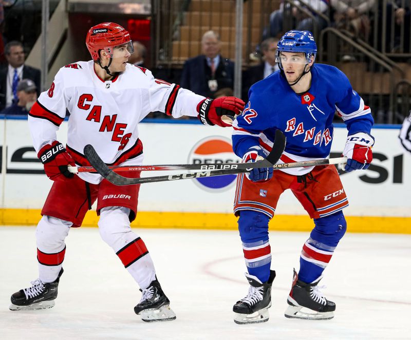 Jan 2, 2024; New York, New York, USA; Carolina Hurricanes center Jack Drury (18) and New York Rangers center Jonny Brodzinski (22) battle for position during the second period at Madison Square Garden. Mandatory Credit: Danny Wild-USA TODAY Sports