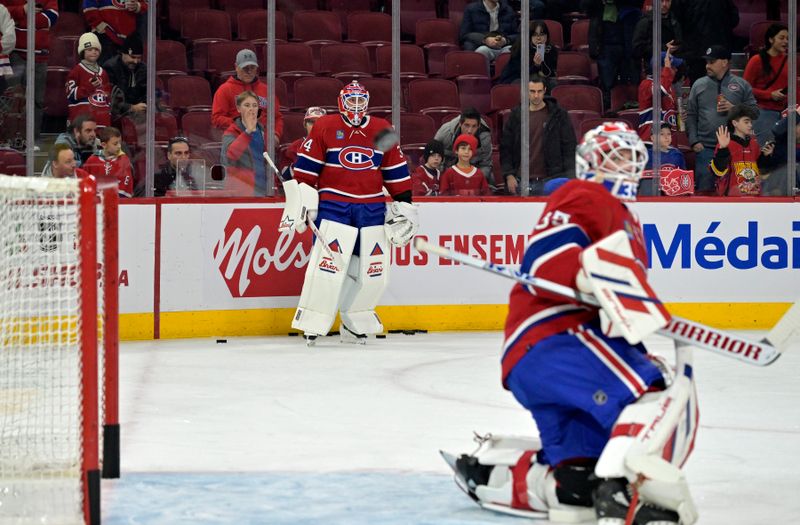 Dec 7, 2023; Montreal, Quebec, CAN; Montreal Canadiens goalie Jake Allen (34) looks an as teammate goalie Sam Montembeault (35) stops a shot during the warmup period before the game against the Los Angeles Kings at the Bell Centre. Mandatory Credit: Eric Bolte-USA TODAY Sports