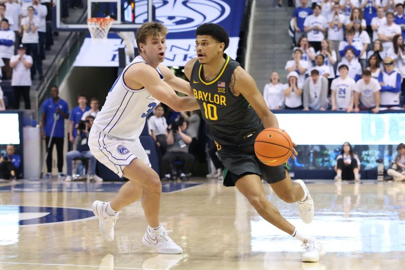 Feb 20, 2024; Provo, Utah, USA; Baylor Bears guard RayJ Dennis (10) drives against Brigham Young Cougars guard Dallin Hall (30) during the first half at Marriott Center. Mandatory Credit: Rob Gray-USA TODAY Sports