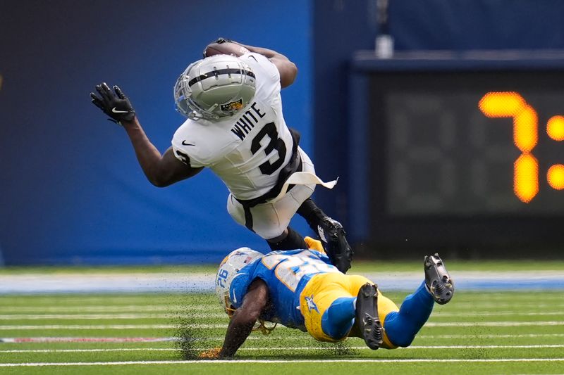 Las Vegas Raiders running back Zamir White (3) is tackled by Los Angeles Chargers cornerback Asante Samuel Jr. during the first half of an NFL football game, Sunday, Sept. 8, 2024, in Inglewood, Calif. (AP Photo/Marcio Jose Sanchez)