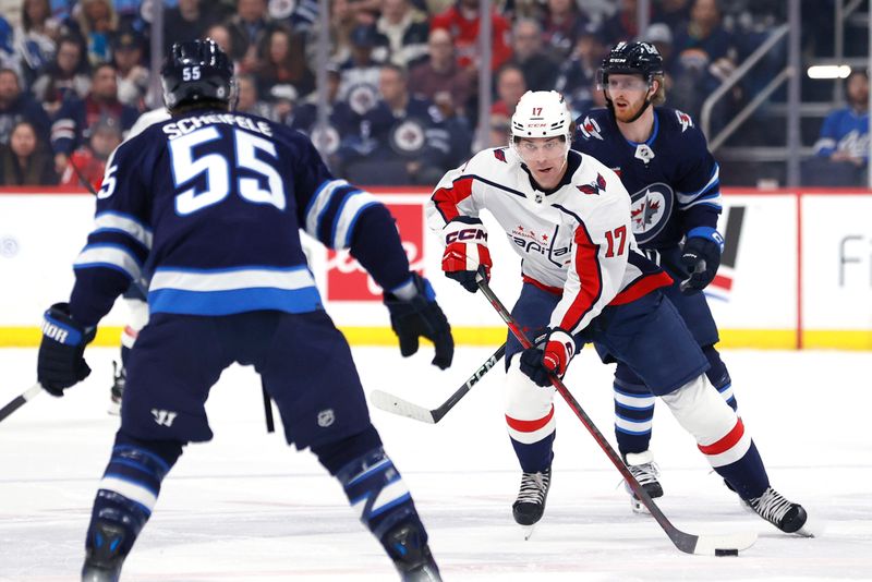 Mar 11, 2024; Winnipeg, Manitoba, CAN; Washington Capitals center Dylan Strome (17) skates up the ice to Winnipeg Jets center Mark Scheifele (55) in the first period at Canada Life Centre. Mandatory Credit: James Carey Lauder-USA TODAY Sports