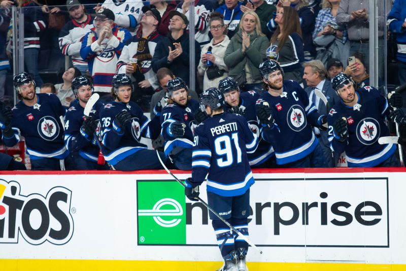 Jan 9, 2024; Winnipeg, Manitoba, CAN; Winnipeg Jets forward Cole Perfetti (91) is congratulated by his teammates on his goal against the Columbus Blue Jackets during the second period at Canada Life Centre. Mandatory Credit: Terrence Lee-USA TODAY Sports