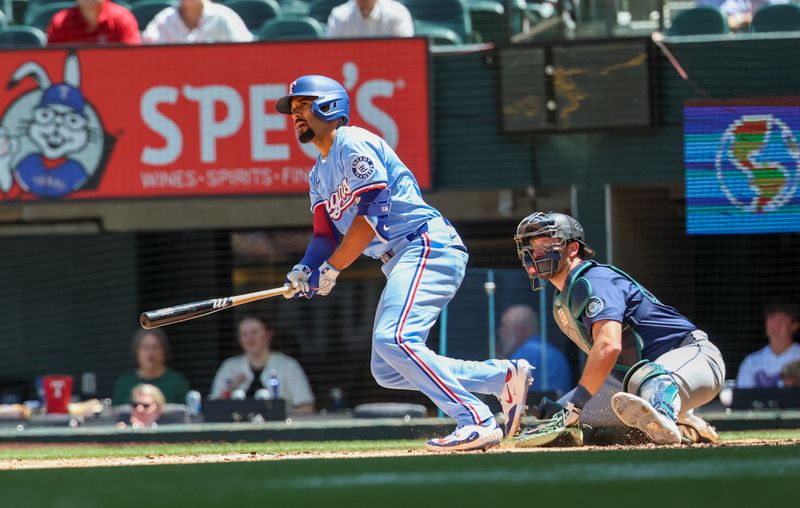 May 4, 2025; Arlington, Texas, USA;  Texas Rangers shortstop Corey Seager (5) hits an rbi single during the third inning against the Seattle Mariners at Globe Life Field. Mandatory Credit: Kevin Jairaj-Imagn Images