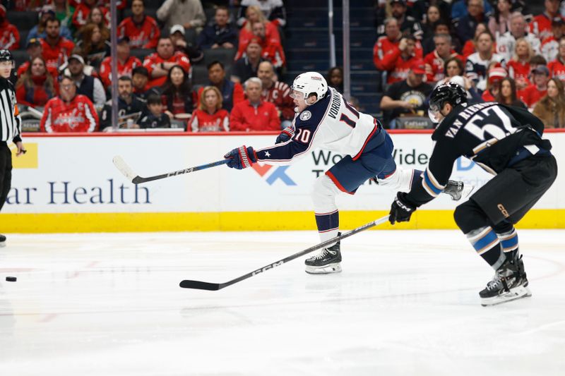 Apr 13, 2025; Washington, District of Columbia, USA; Columbus Blue Jackets left wing Dmitri Voronkov (10) shoots the puck as Washington Capitals defenseman Trevor van Riemsdyk (57) defends in the first period at Capital One Arena. Mandatory Credit: Geoff Burke-Imagn Images