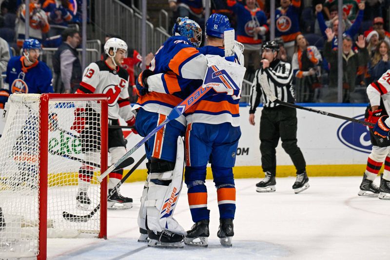 Dec 23, 2025; Elmont, New York, USA;  New York Islanders goaltender David Rittich (33) celebrates the 2-1 victory over the New Jersey Devils with left wing Emil Heineman (51) after the game at UBS Arena. Mandatory Credit: Dennis Schneidler-Imagn Images