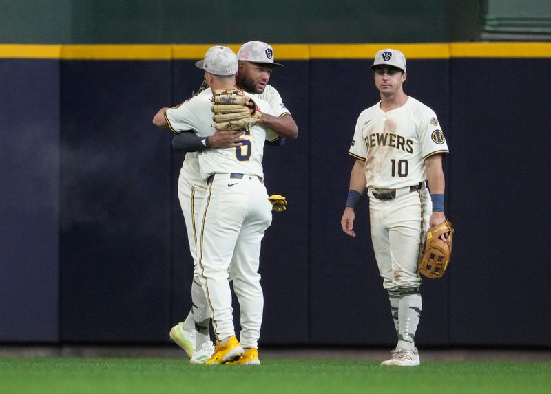 May 18, 2025; Milwaukee, Wisconsin, USA; Milwaukee Brewers outfielder Jackson Chourio (11) and Milwaukee Brewers outfielder Isaac Collins (6) celebrate a 5-2 win over the Minnesota Twins as Milwaukee Brewers outfielder Sal Frelick (10) looks on at American Family Field. Mandatory Credit: Michael McLoone-Imagn Images
