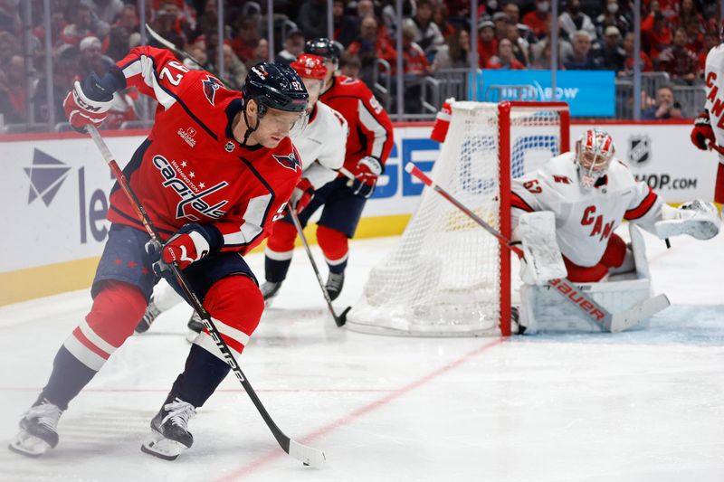 Jan 5, 2024; Washington, District of Columbia, USA; Washington Capitals center Evgeny Kuznetsov (92) skates with the puck behind Carolina Hurricanes goaltender Pyotr Kochetkov (52) in the third period at Capital One Arena. Mandatory Credit: Geoff Burke-USA TODAY Sports