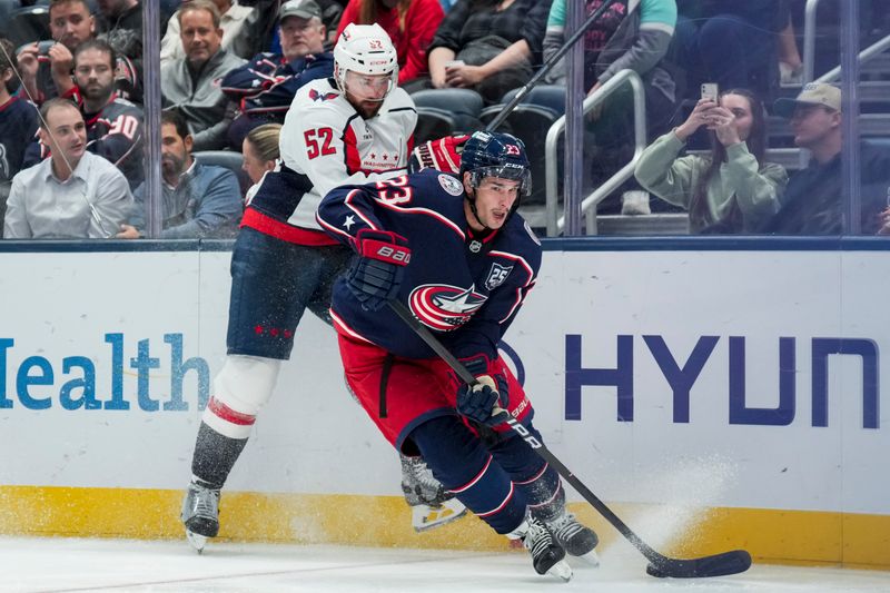 Sep 30, 2025; Columbus, Ohio, USA; Columbus Blue Jackets center Sean Monahan (23) skates with the puck against Washington Capitals defenseman Dylan McIlrath (52) in the third period at Nationwide Arena. Mandatory Credit: Aaron Doster-Imagn Images