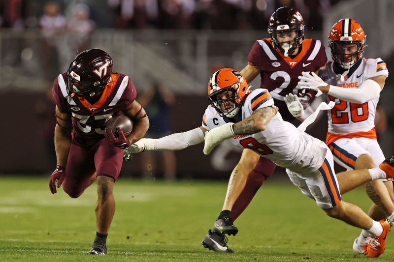 Oct 26, 2023; Blacksburg, Virginia, USA; Virginia Tech Hokies running back Bhayshul Tuten (33) runs the ball against Syracuse Orange defensive back Justin Barron (8) during the fourth quarter at Lane Stadium. Mandatory Credit: Peter Casey-USA TODAY Sports