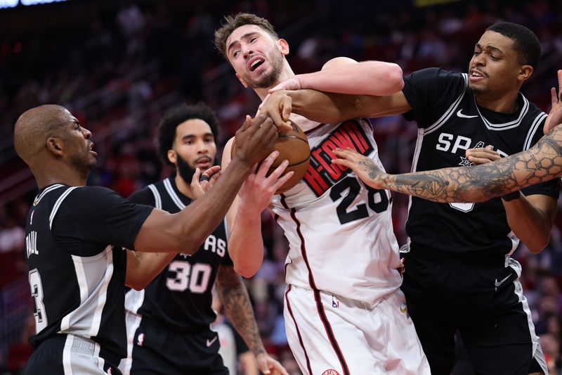 HOUSTON, TEXAS - FEBRUARY 26: Alperen Sengun #28 of the Houston Rockets battles for the ball with Chris Paul #3 and Keldon Johnson #0 of the San Antonio Spurs  during the first half at Toyota Center on February 26, 2025 in Houston, Texas. NOTE TO USER: User expressly acknowledges and agrees that, by downloading and or using this photograph, User is consenting to the terms and conditions of the Getty Images License Agreement. (Photo by Alex Slitz/Getty Images)