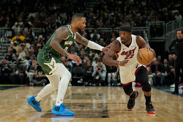 MILWAUKEE, WISCONSIN - OCTOBER 30: Jimmy Butler #22 of the Miami Heat dribbles the ball against Damian Lillard #0 of the Milwaukee Bucks during the second half at Fiserv Forum on October 30, 2023 in Milwaukee, Wisconsin. NOTE TO USER: User expressly acknowledges and agrees that, by downloading and or using this photograph, User is consenting to the terms and conditions of the Getty Images License Agreement. (Photo by Patrick McDermott/Getty Images)