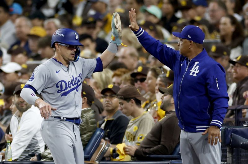 Oct 9, 2024; San Diego, California, USA; Los Angeles Dodgers third baseman Enrique Hernandez (8) celebrates with manager Dave Roberts (30) after scoring in the second inning against the San Diego Padres during game four of the NLDS for the 2024 MLB Playoffs at Petco Park. Mandatory Credit: David Frerker-Imagn Images