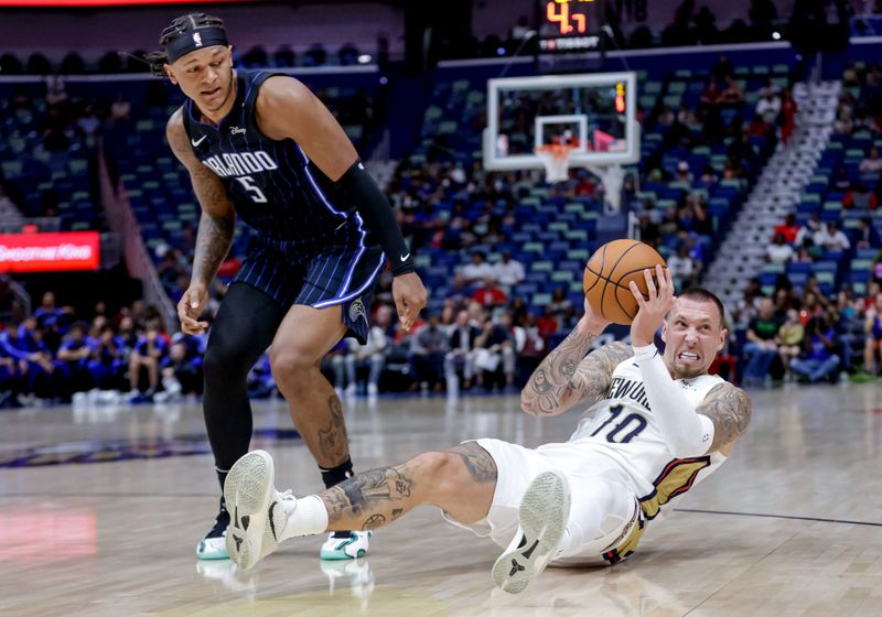 NEW ORLEANS, LOUISIANA - OCTOBER 7:  Daniel Theis #10 of the New Orleans Pelicans recovers a loose ball as Paolo Banchero #5 of the Orlando Magic defends during the first half of a preseason game at the Smoothie King Center on October 7, 2024 in New Orleans, Louisiana. NOTE TO USER: User expressly acknowledges and agrees that, by downloading and or using this photograph, User is consenting to the terms and conditions of the Getty Images License Agreement. (Photo by Derick E. Hingle/Getty Images)