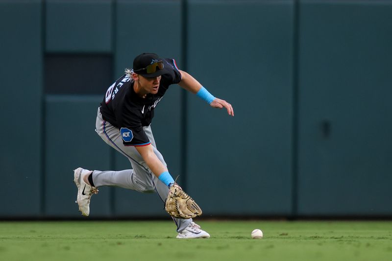 Aug 3, 2024; Atlanta, Georgia, USA; Miami Marlins left fielder Kyle Stowers (28) fields a ball against the Atlanta Braves in the second inning at Truist Park. Mandatory Credit: Brett Davis-USA TODAY Sports