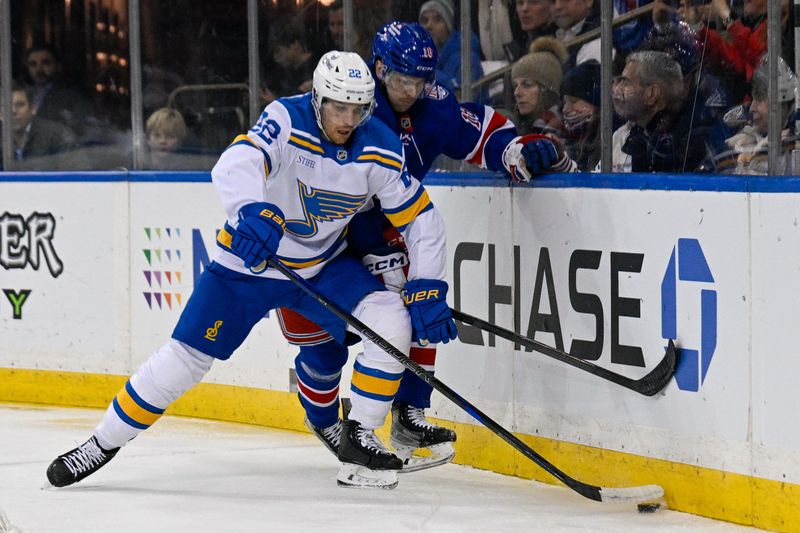 Nov 24, 2025; New York, New York, USA;  New York Rangers defenseman Urho Vaakanainen (18) and St. Louis Blues center Pius Suter (22) battle for the puck during the first period at Madison Square Garden. Mandatory Credit: Dennis Schneidler-Imagn Images
