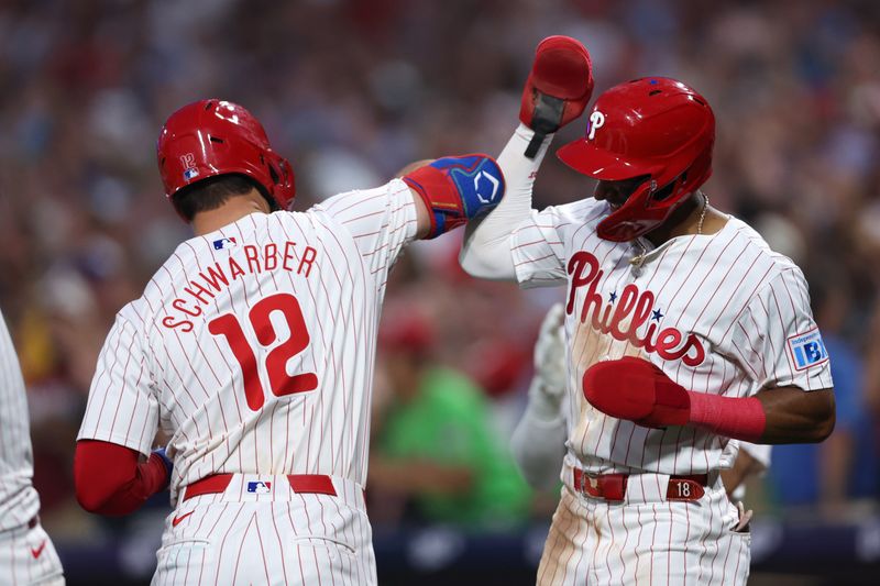 Aug 14, 2024; Philadelphia, Pennsylvania, USA; Philadelphia Phillies designated hitter Kyle Schwarber (12) celebrates with outfielder Johan Rojas (18) after hitting a four RBI grand slam during the fourth inning against the Miami Marlins at Citizens Bank Park. Mandatory Credit: Bill Streicher-USA TODAY Sports