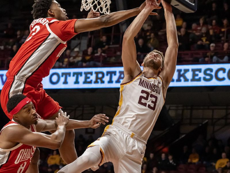 Jan 6, 2025; Minneapolis, Minnesota, USA;  Minnesota Golden Gophers forward Parker Fox (23) goes to the basket as Ohio State Buckeyes forward Sean Stewart (13) and guard Micah Parrish (8) defend during the first half at Williams Arena. Mandatory Credit: Nick Wosika-Imagn Images