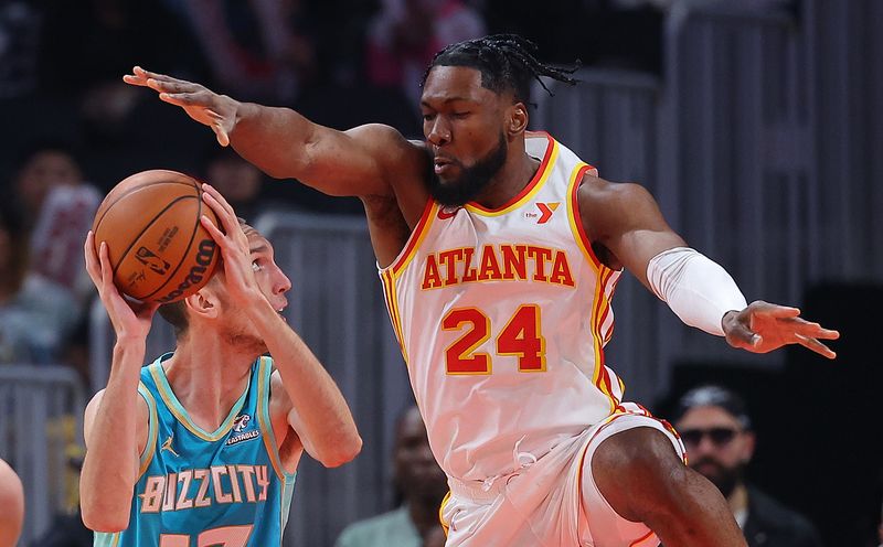 ATLANTA, GEORGIA - MARCH 23:  Aleksej Pokusevski #17 of the Charlotte Hornets draws a foul from Bruno Fernando #24 of the Atlanta Hawks during the first quarter at State Farm Arena on March 23, 2024 in Atlanta, Georgia.  NOTE TO USER: User expressly acknowledges and agrees that, by downloading and/or using this photograph, user is consenting to the terms and conditions of the Getty Images License Agreement.  (Photo by Kevin C. Cox/Getty Images)