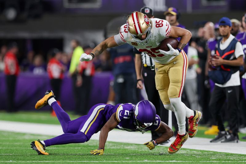 San Francisco 49ers tight end George Kittle (85) handles the ball against Minnesota Vikings cornerback Akayleb Evans (21) during the first half of an NFL football game Monday, Oct. 23, 2023 in Minneapolis. (AP Photo/Stacy Bengs)
